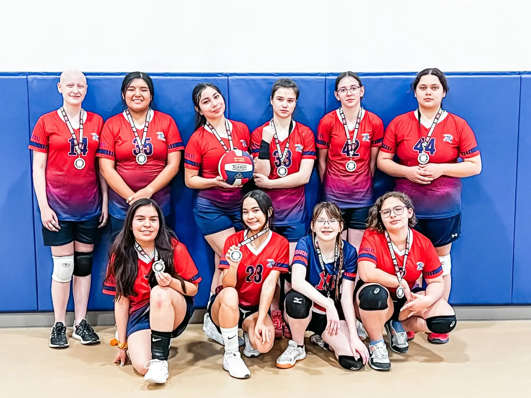 The NECA girls volleyball team standing together in uniform after a tournament.